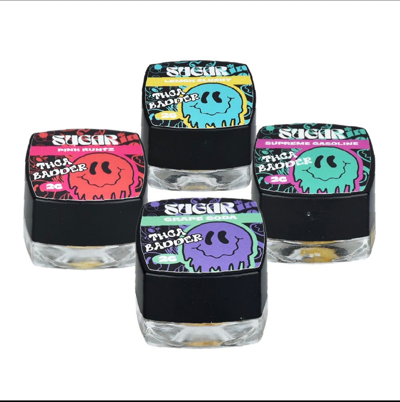 Four small square Trippy Sugar THCa Badder 2G jars from Trippy Sugar, each in red, blue, green, and purple labels with unique flavors, are clustered together. Each jar contains premium 2G Dab.