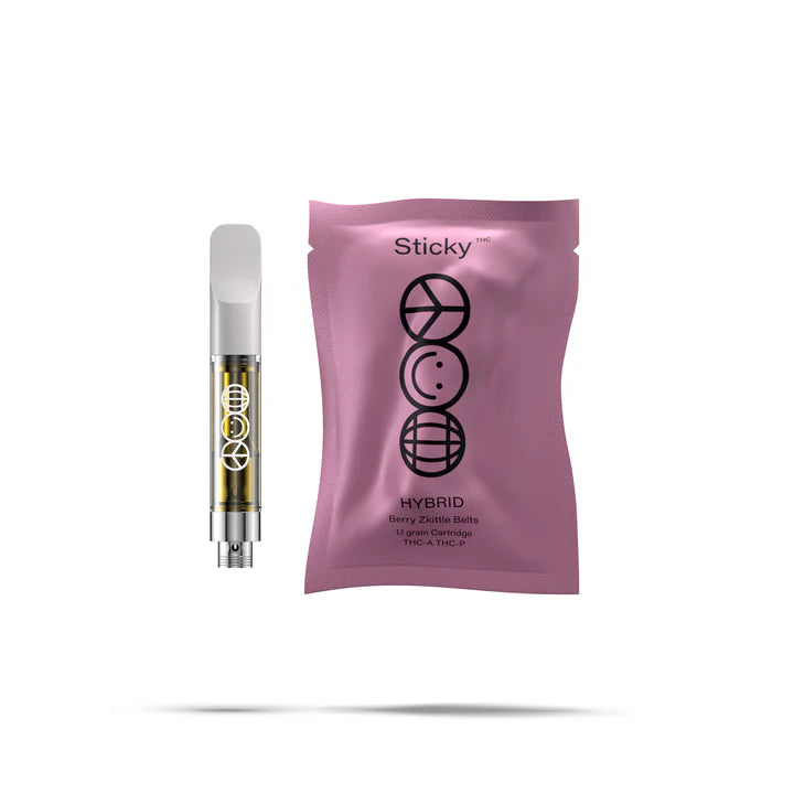 A QWIN Puffy Sticky THCA Cartridge (1.1G) with yellow liquid stands beside a sealed purple pouch labeled Sticky Sativa Blue Slurps, both featuring black circular geometric designs, set against a white background.