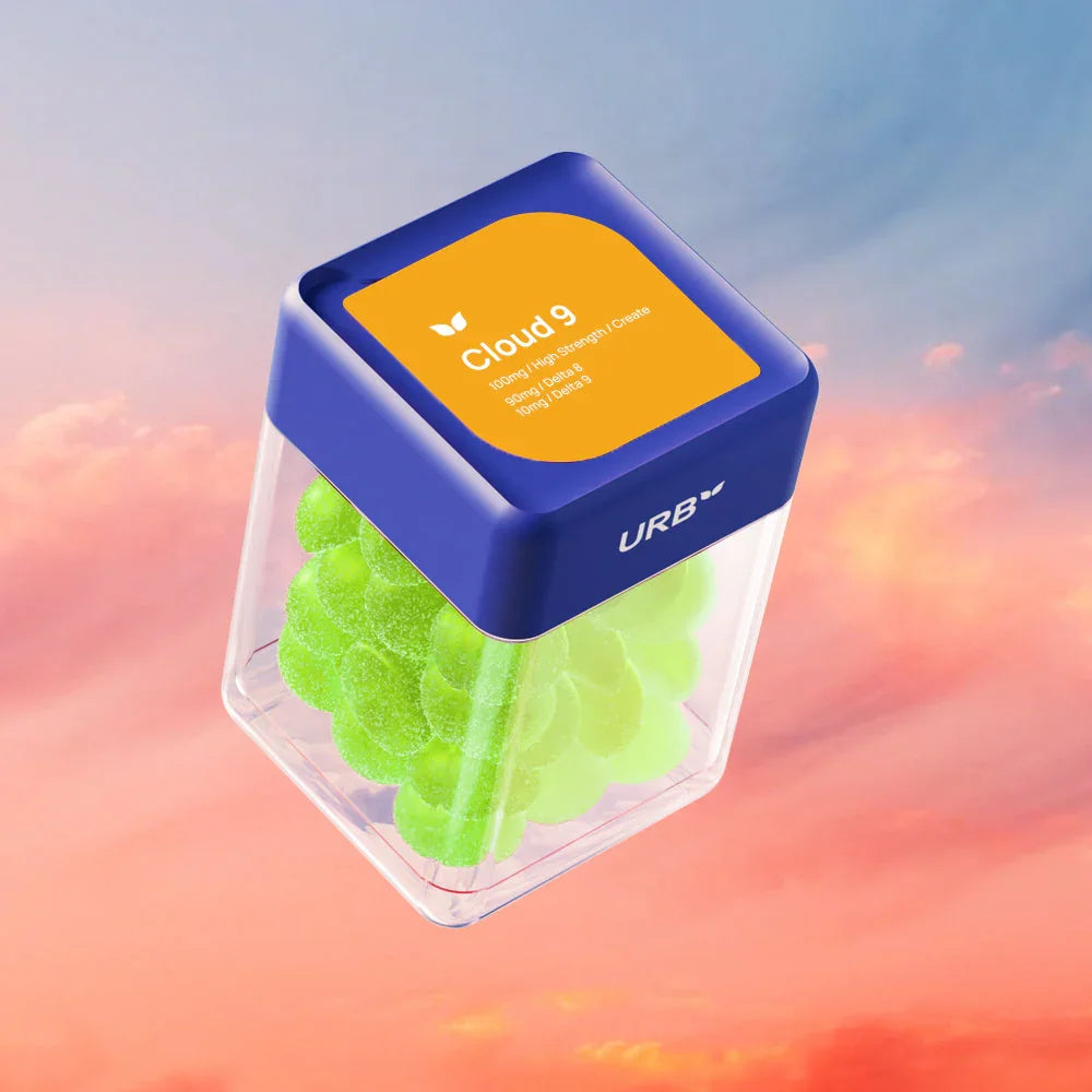 A clear container with a blue lid labeled Urb Cloud 9 Skybites Gummies 100MG (30ct.) holds green gummies, floating against a colorful sky with soft clouds in the background.