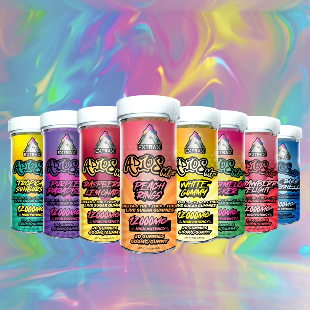 Seven Delta Extrax Adios MF THCA Gummies (12,000mg) containers are lined up before a vibrant rainbow swirl. Each jar shows a different flavor, showcasing these high-potency edibles from Delta Extrax.